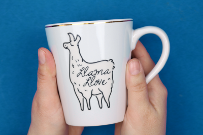 hands holding white mug with Llama Llove ceramic sticker