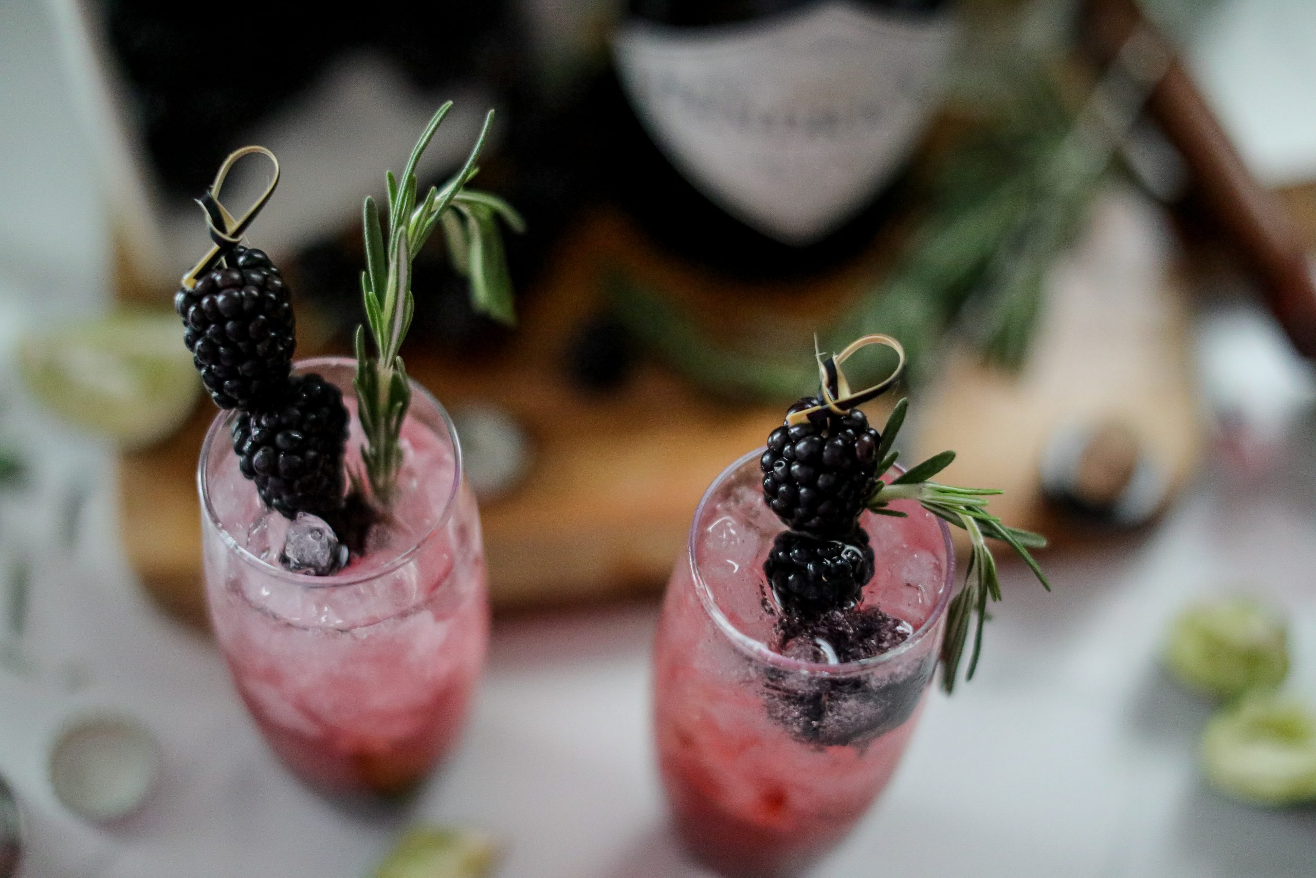 blackberry gin and tonics garnished with fresh berries and rosemary