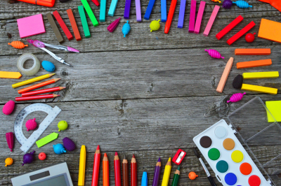 colorful school supplies arranged on a wood table