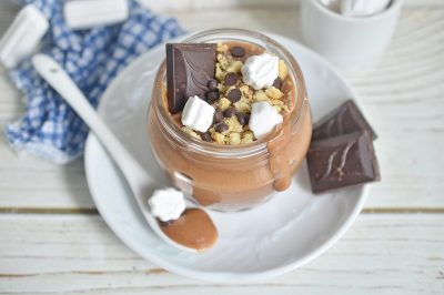 mason jar of smores pudding on a plate with a spoon