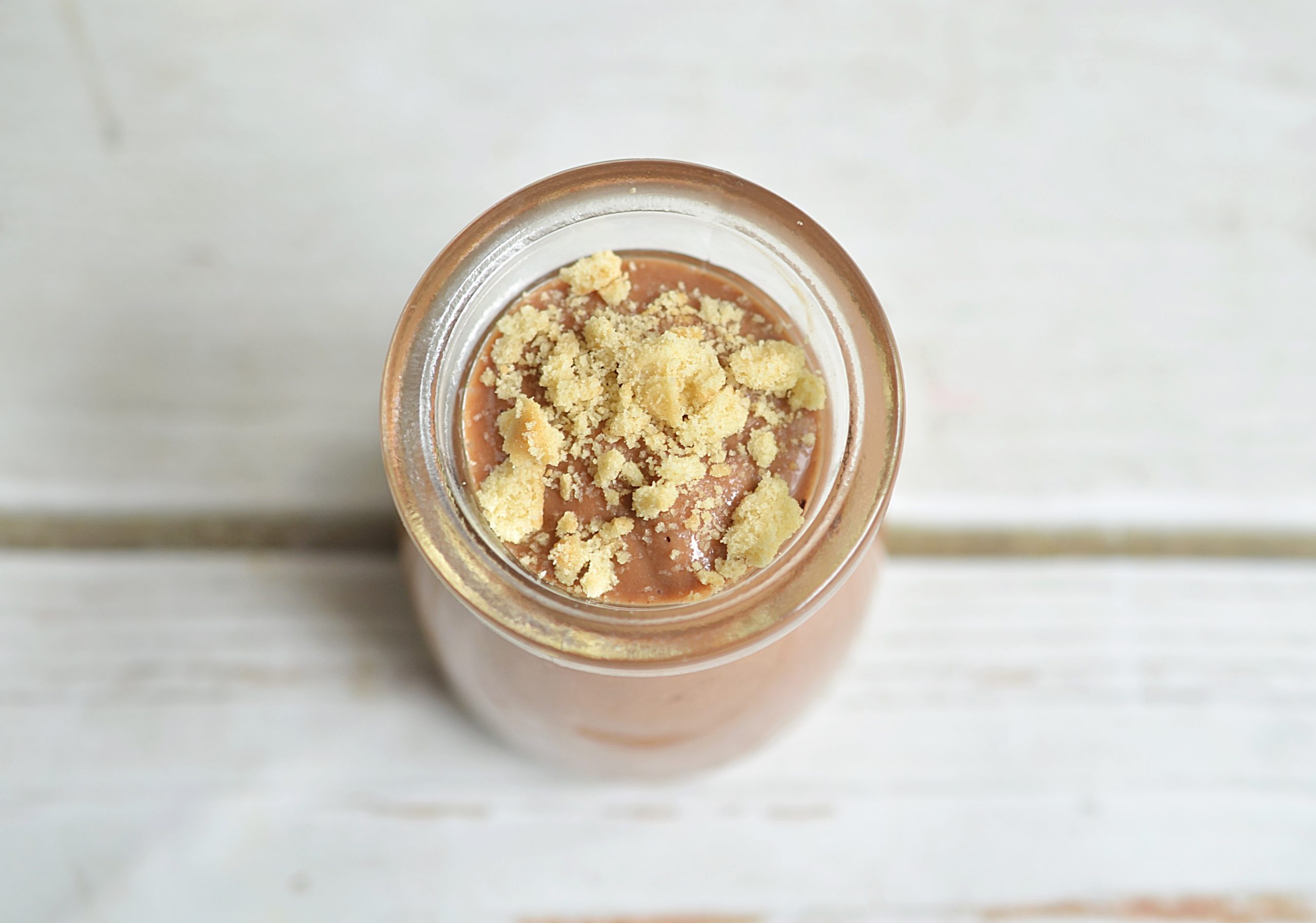 chocolate pudding topped with graham cracker crumbs in a jar