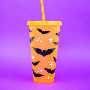 orange straw cup with bat decorations on a purple background