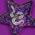 star shaped ring dish made with glittery resin and decorated with a vinyl snake