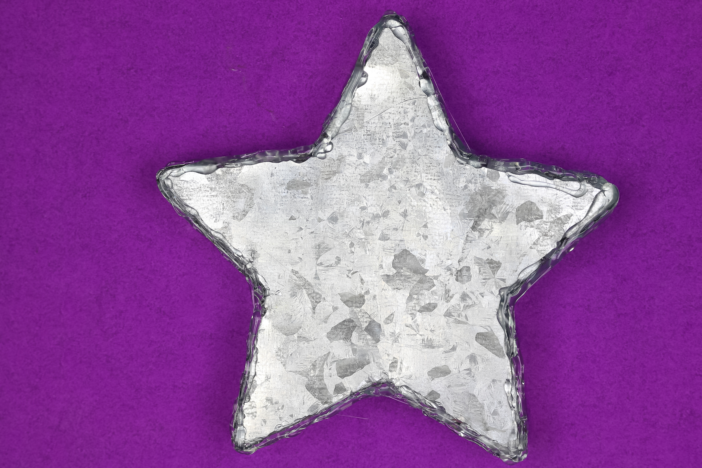 back of a galvanized metal star tray from Dollar Tree covered with hot glue