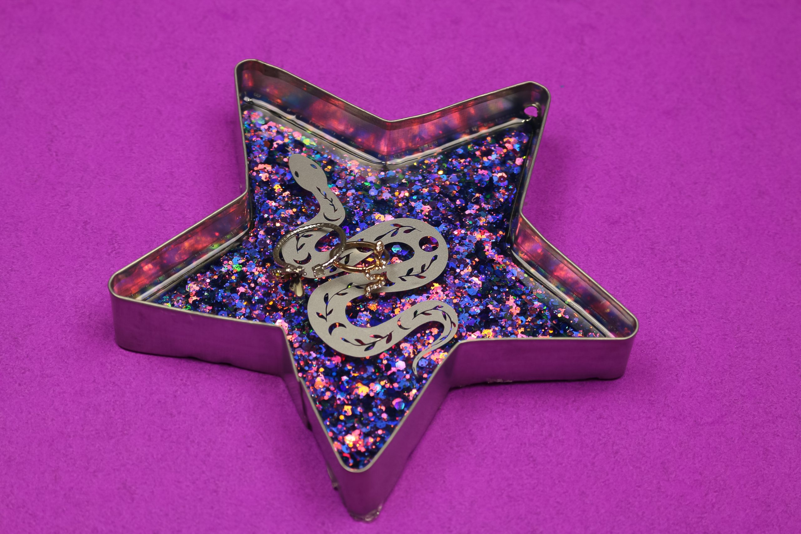 side view of star shaped ring dish made with glittery resin and decorated with a vinyl snake