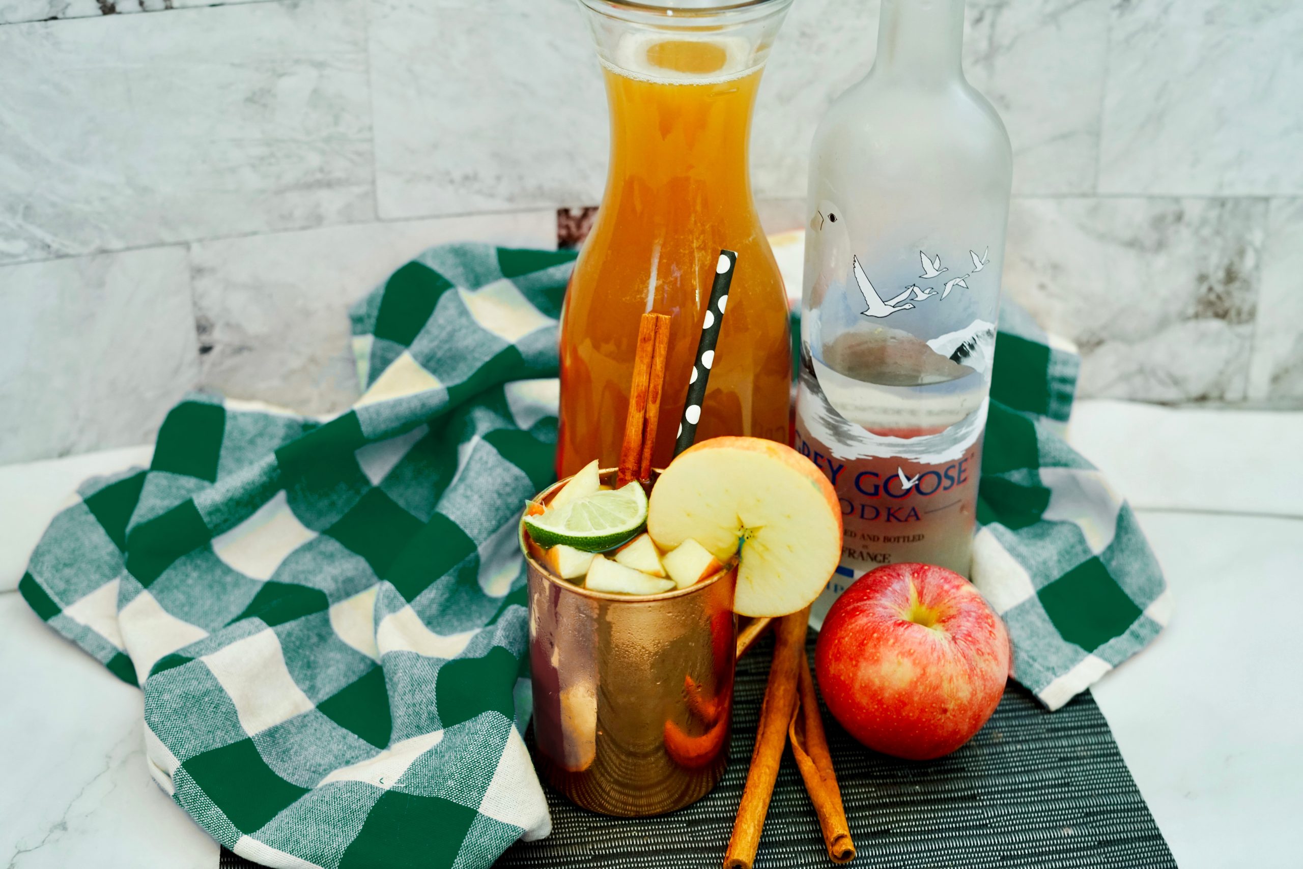 Apple cider mule in a copper mug near the cocktail ingredients