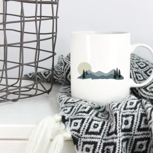 mountain scene mug near a cozy blanket