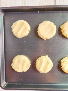 sugar cookies pressed on a baking sheet