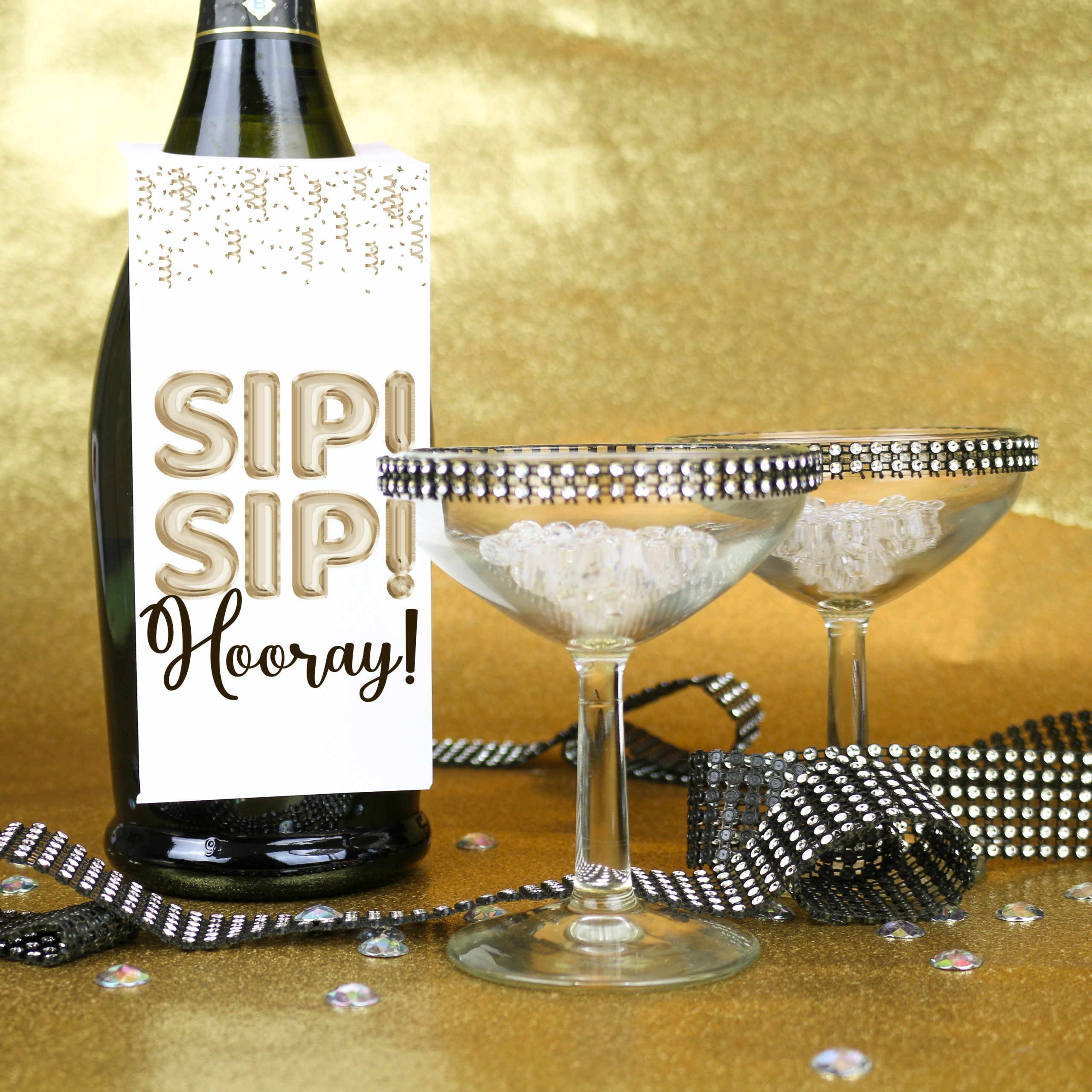 Champagne bottle with Sip! Sip! Hooray! bottle tag by champagne coupeson a gold background