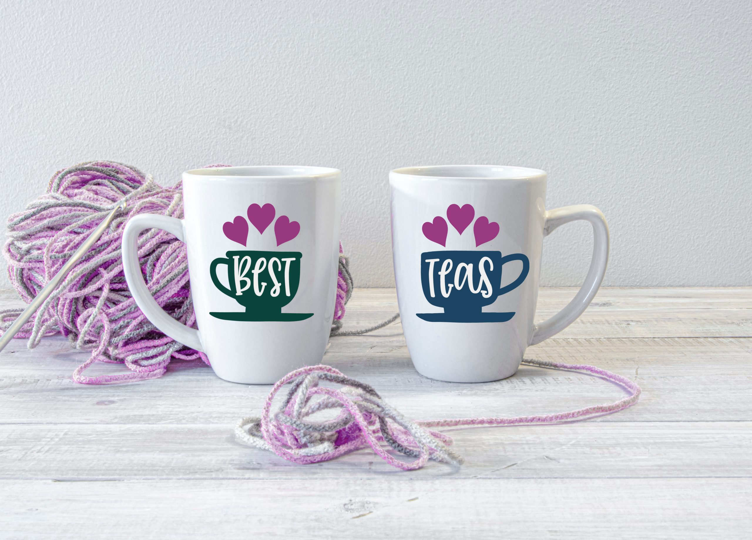 white mugs with Best and Teas designs near yarn