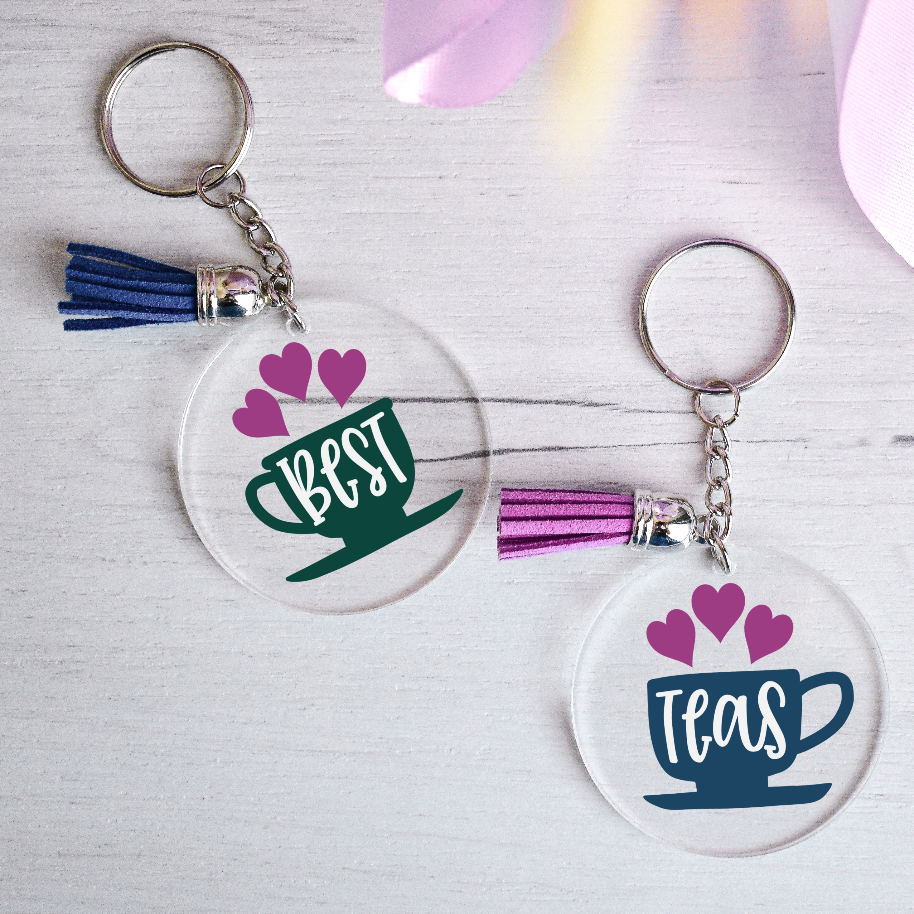 two acrylic key chains with Best and Teas in vinyl