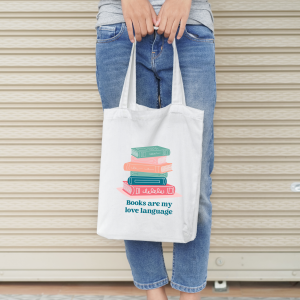 woman holding tote bag with a book svg design