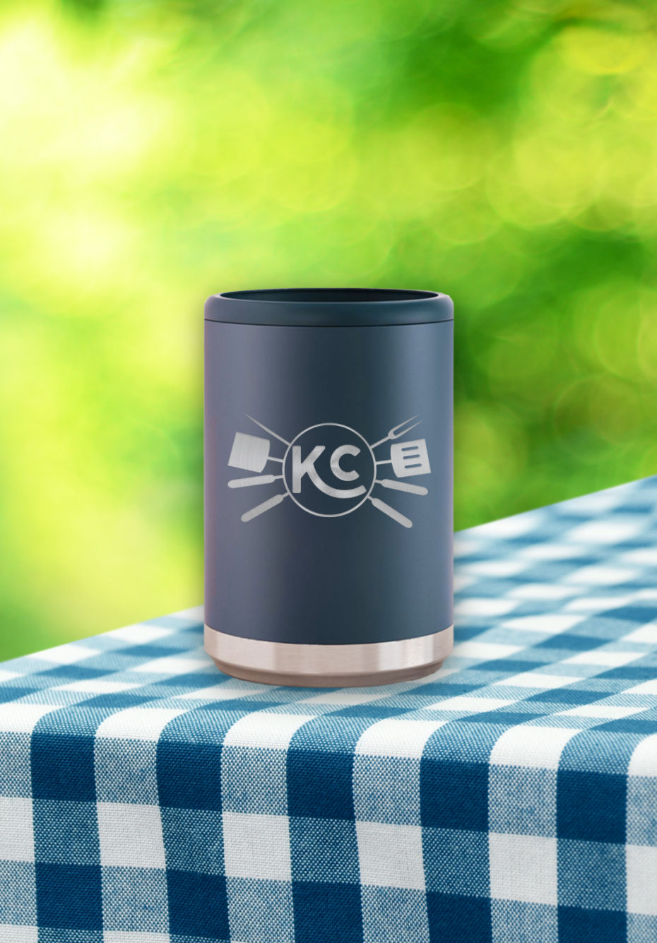 Etched metal can cooler on a blue and white checked tablecloth outdoors