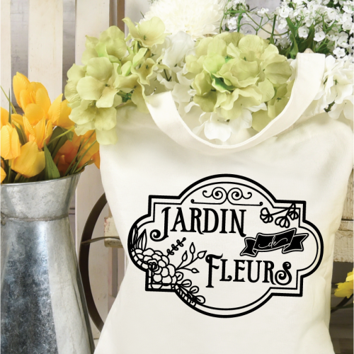 Canvas tote bag holding flowers. The tote is decorated with Jardin Fleurs design