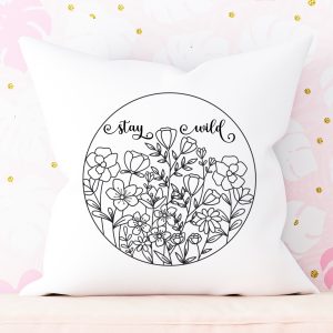 White pillow with a floral Stay Wild design