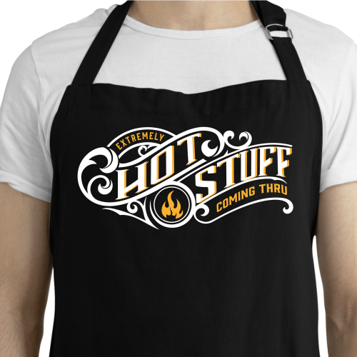 White man wearing a black apron that reads Extremely Hot Stuff Coming Through
