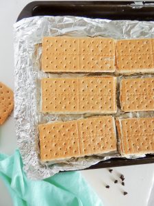 Graham cracker ice cream sandwiches on a baking tray lined with foil