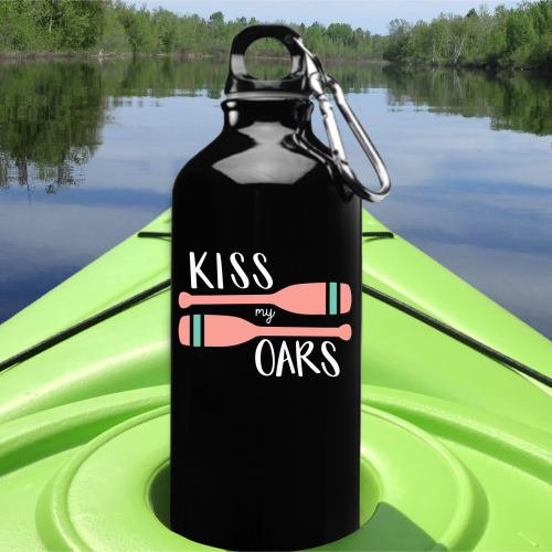 Black water bottle with Kiss My Oars design at the front of a kayak