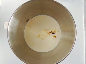 Metal mixing bowl of heavy cream and vanilla