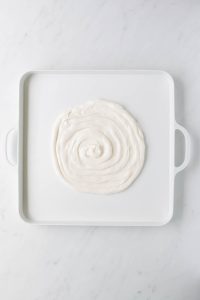 white frosting piped onto the middle of a large platter