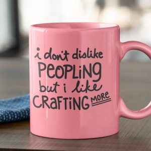Pink mug that reads: I don't disklike peopling but I like crafting more