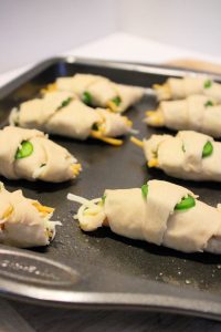 cheesy jalapeno crescent rolls on a baking sheet