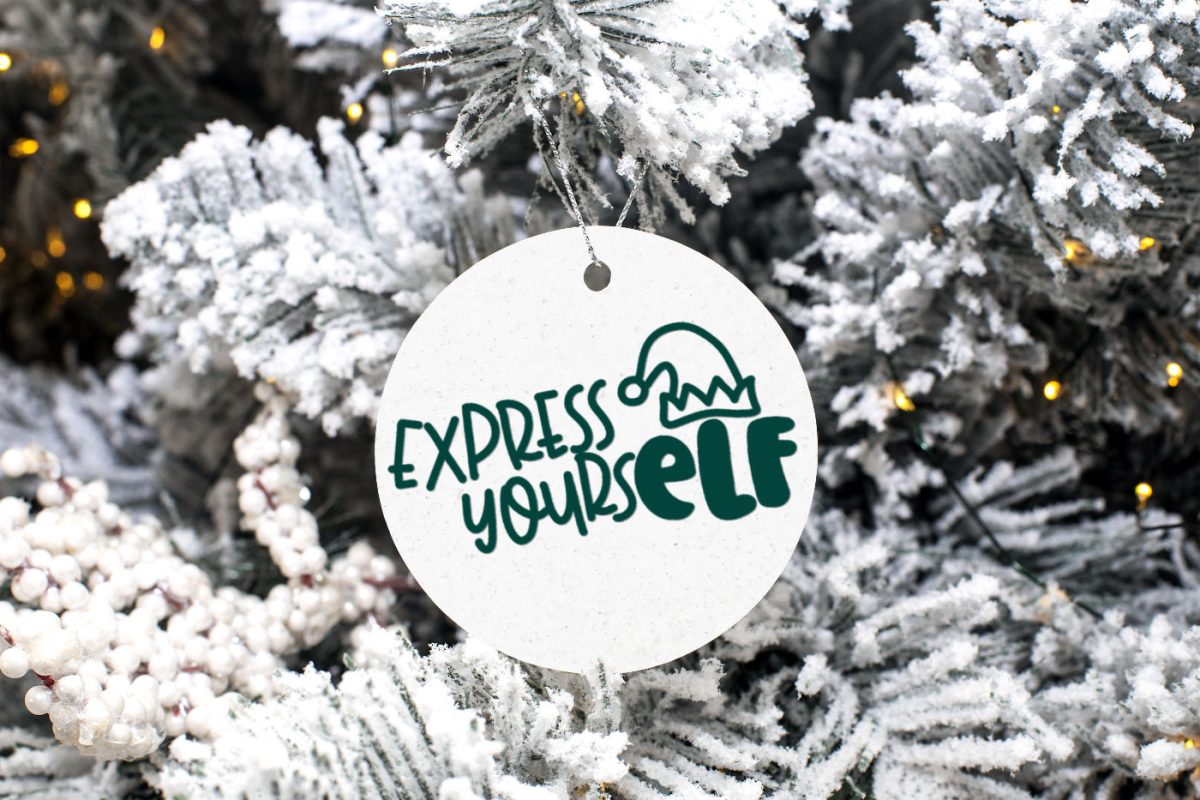 White disc ornament with Express YoursELF design on a flocked Christmas tree