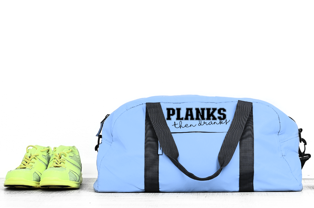light blue gym bag with Planks Then Dranks SVG on it