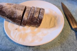 log of chocolate shortbread dough rolled in sugar and sliced