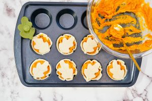 muffin pan with mini pumpkin pies decorated with pie crust leaves