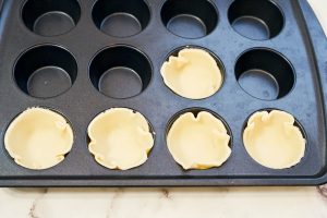 pie crust circles pressed into a muffin pan