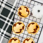 mini pumpkin pies on a cooling rack near a plaid napkin