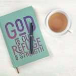 Teal notebook with a cover that says "God is our refuge & strength"