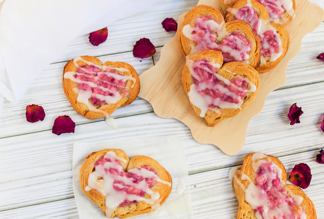 heart-shaped danish pastries near rose petals