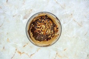 melted fudge ingredients in a bowl with pecans
