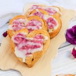 heart shaped raspberry cream cheese danishes on a cutting board