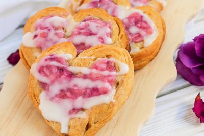 heart shaped raspberry cream cheese danishes on a cutting board