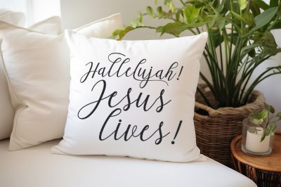 Jesus Lives SVG on a white pillow sitting on a white couch near plants