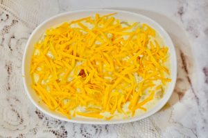 baking dish of cheesy potatoes topped with shredded cheese