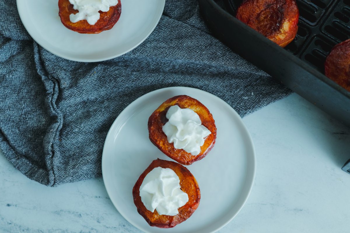top down view of a plate of air fried peaches topped with whipped cream