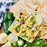 closer view of a bowl of corn salsa near fresh ingredients