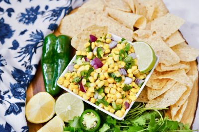 closer view of a bowl of corn salsa near fresh ingredients