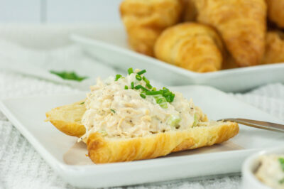 Horizontal side view of open faced chicken salad sandwich on a croissant
