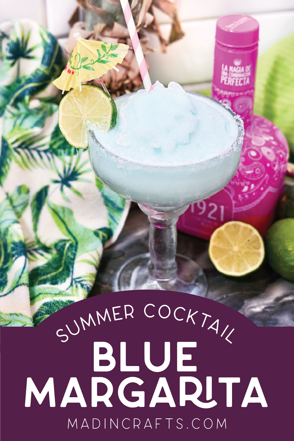 frozen blue margarita garnished with a lime slice near a bottle of tequila and a pineapple
