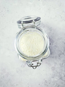 glass container with lid holding powdered milk