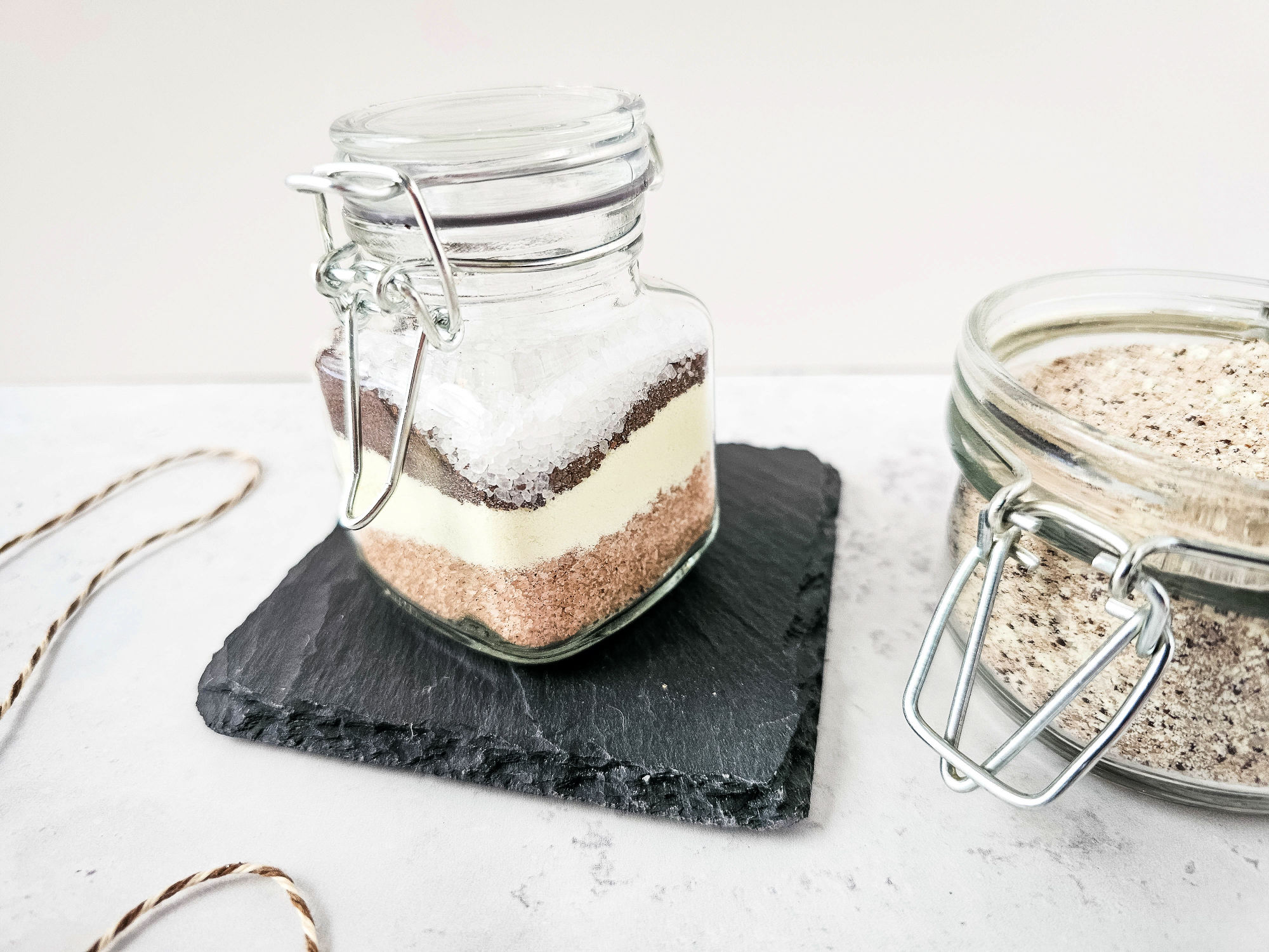 a jar with the layered ingredients for pumpkin spice latte bath soak