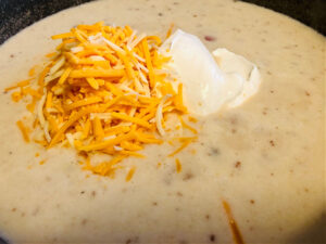 baked potato soup topped with cheese and sour cream