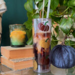 creamer poured into a clear acrylic tumbler with vinyl decorations near fall decor