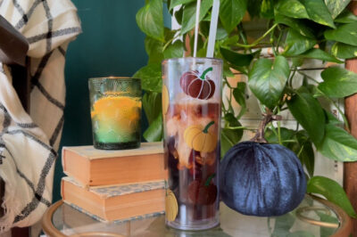 creamer poured into a clear acrylic tumbler with vinyl decorations near fall decor