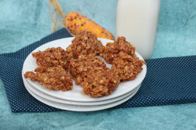 side view of pumpkin no bakes on a white plate near a bottle of milk